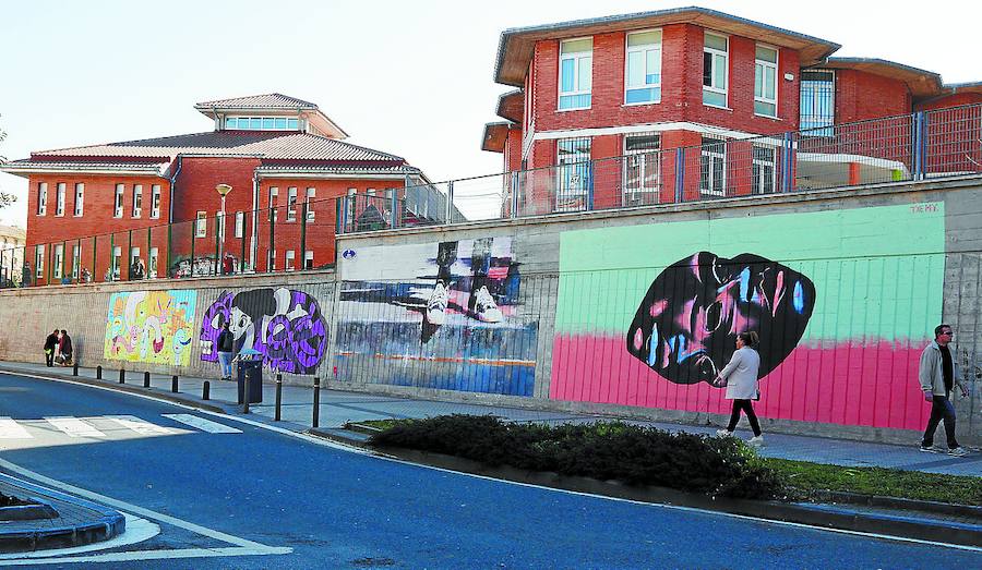 Murales en la valla que separa de la calle el edificio de Infantil. El de la derecha esconde dos caras.