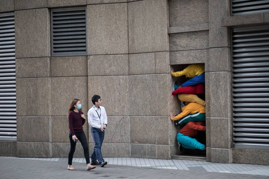 Bailarines hacen de esculturas humanas en la «Exposición multisensorial de parques de juegos urbanos», del artista austriaco Willi Dorner, este martes en Hong Kong. El artista utiliza espacios urbanos para reinterpretar la relación entre los cuerpos y los objetos.