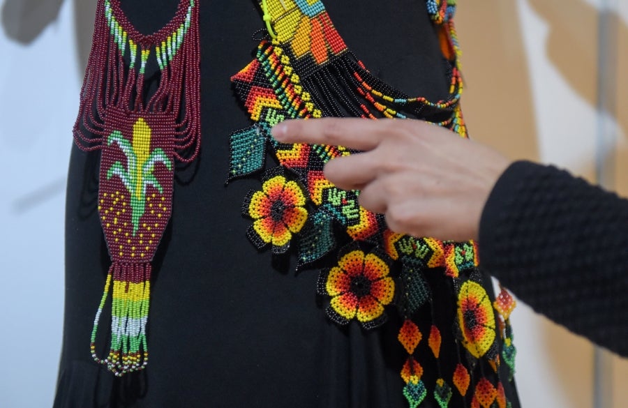 La colombiana Roxana Panchi Gutiérrez, una joven transexual indígena de 24 años, se reúne con sus dos amigas de toda la vida, en el pueblo indígena Cristiania, departamento de Antioquia, para crear accesorios con cuentas. Las mismas cuentas que iluminan las últimas creaciones de la diseñadora colombiana Laura Laurens, cuyos diseños viajan desde Bogotá a Londres, París y Nueva York.