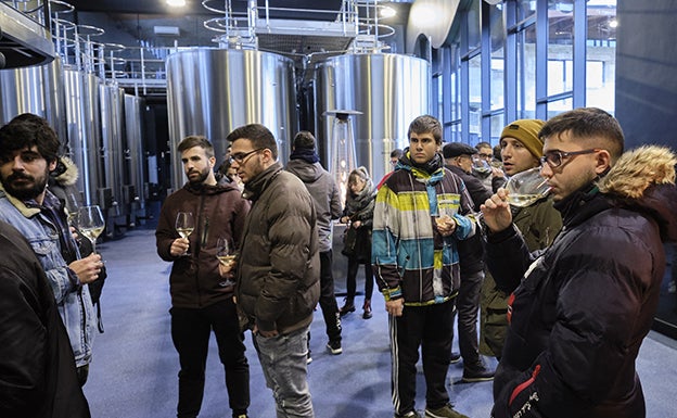 Cata del rico txakoli entre las barricas de la bodega.