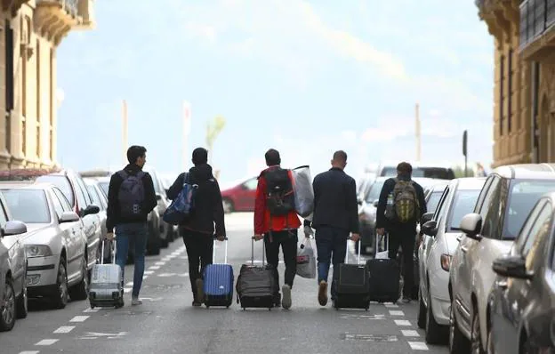 Un grupo de turistas se despide de San Sebastián con sus maletas
