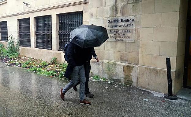 El 'Chapuzas' se oculta bajo el paraguas de su abogado. 