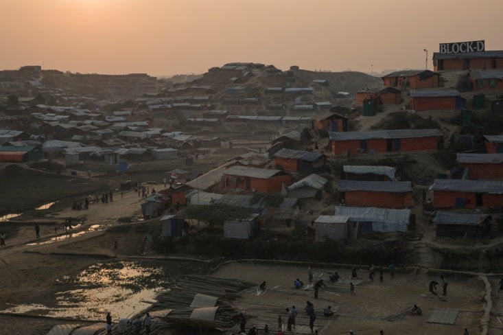 Abrigo . Más de 930.000 refugiados rohingyas viven ahora hacinados en precarios asentamientos improvisados en el distrito bangladesí de Cox’s Bazar. Sus hogares, pequeñas tiendas construidas a base de cañas de bambú y plástico, se levantan en los lomos de colinas deforestadas. Con los últimos rayos de sol, en el campo de Jamtoli se oye la llamada al rezo de los muecines, mientras niños y jóvenes juegan al fútbol y al voleibol en antiguos arrozales.