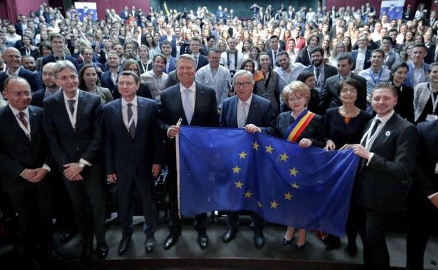 El presidente de la Comisión Europea, Jean-Claude Juncker (c), sostiene la bandera de la UE tras participar en una conferencia'.
