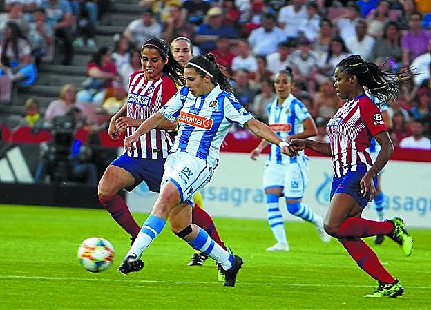 Marta Cardona pasa el balón a una compañera ante el acoso de Kenti Robles mientras·Tounkara sigue de cerca la jugada anoche en Los Cármenes. 