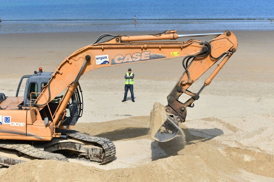 Las excavadoras trabajan ya en las playas donostiarras realizando trabajos de explanación de la arena para poder instalar posteriormente los servicios para el verano (toldos, cafetería, etcétera).