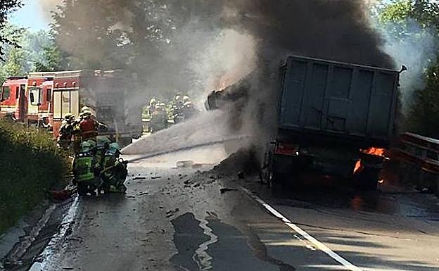 Los bomberos sofocan las llamas en el camión accidentado en el Alto de Barazar.