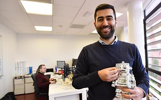 Arkaitz Bastida bromea con una hucha con forma de robot en las oficinas de Sabbatic.