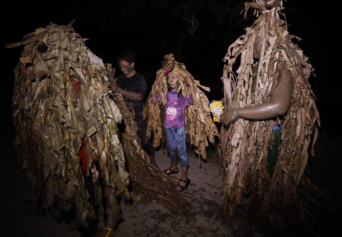 Devotos católicos filipinos de Saint John the Baptist cubiertos de barro y hojas de plátano encienden velas fuera de la Iglesia Parroquial. El ritual de 'Taong Putik' (pueblo de barro) es seguido por una santa misa para conmemorar el día de la fiesta de Saint John the Baptist, mientras los devotos agradecen las oraciones contestadas y esperan una cosecha abundante cada año.