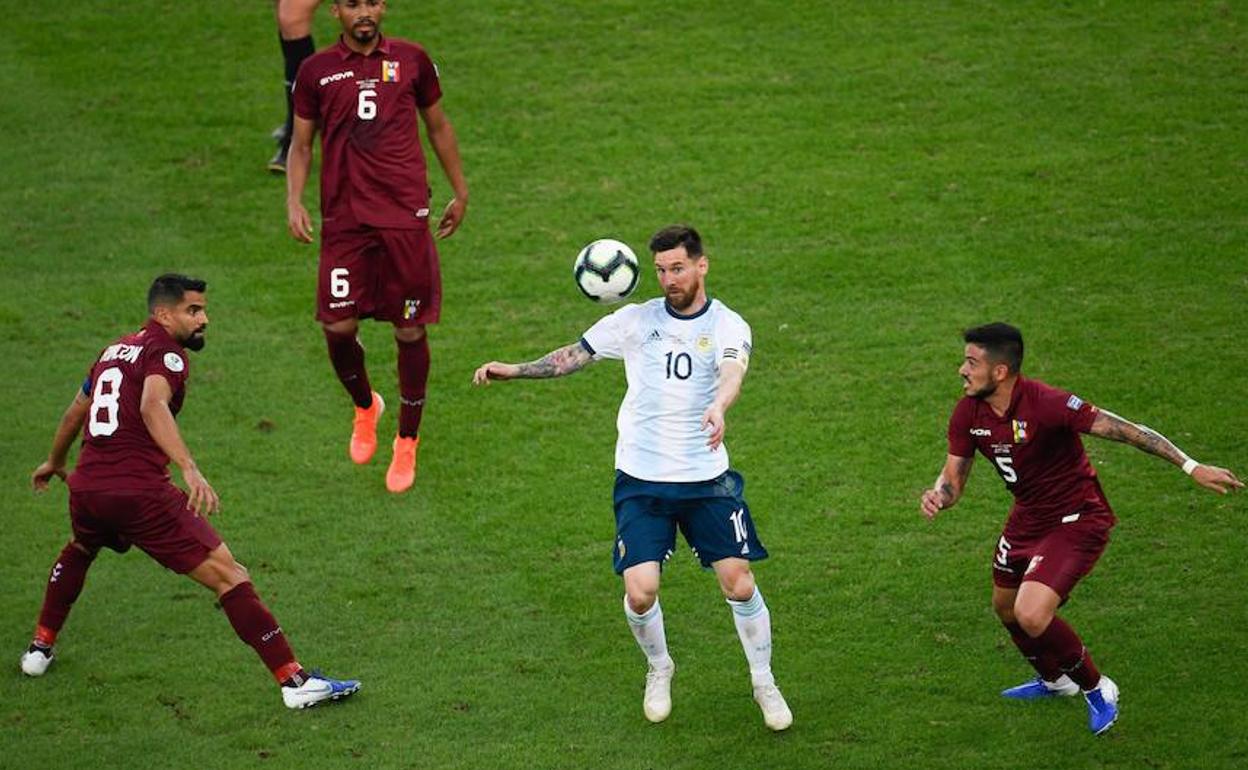 Messi (c) controla el balón ante varios rivales. 