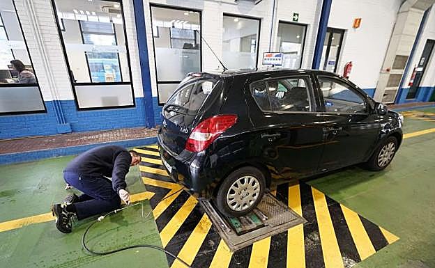 Un trabajador revisa el tubo de escape de un vehículo en la estación de ITV de Urnieta. 