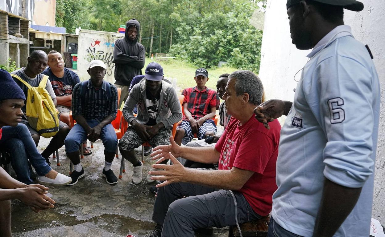 Un grupo de migrantes charla con un voluntario en la zona fronteriza de Irun.