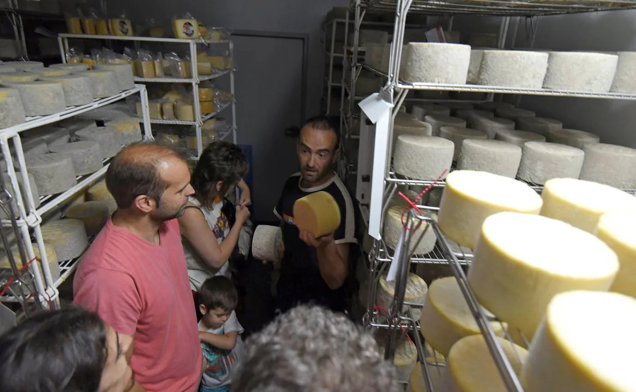Bajo la atenta mirada de los visitantes, el quesero Ander Barandiaran explica los últimos pasos antes de consumir el queso Idiazabal. 