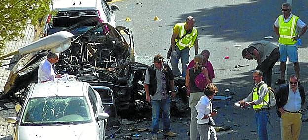 Artificieros de la Guardia Civil analizan el coche patrulla, que se convirtió en un amasijo de hierros tras la explosión.