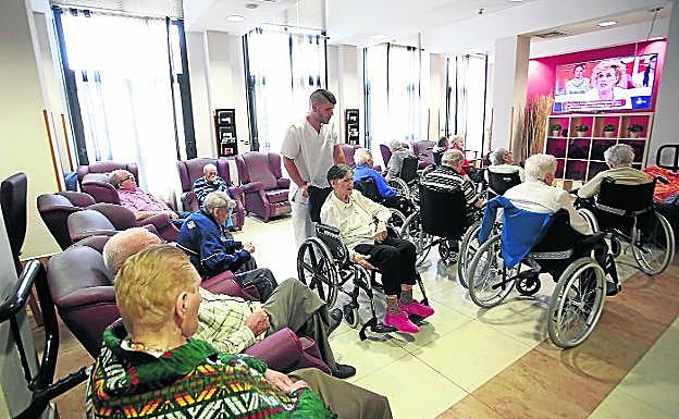 Un grupo de usuarios de una residencia viendo la televisión.