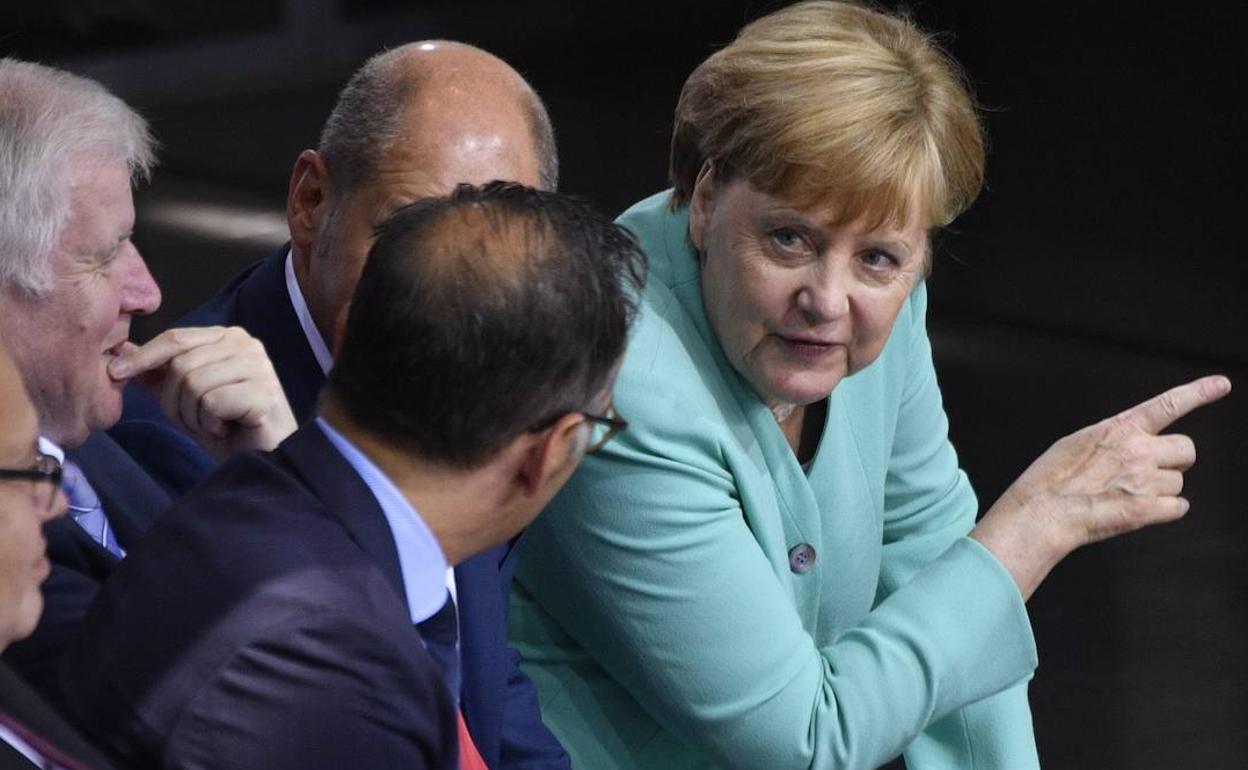 Angela Merkel (d) habla con el ministro de Asuntos Exteriores alemán Heiko Maas