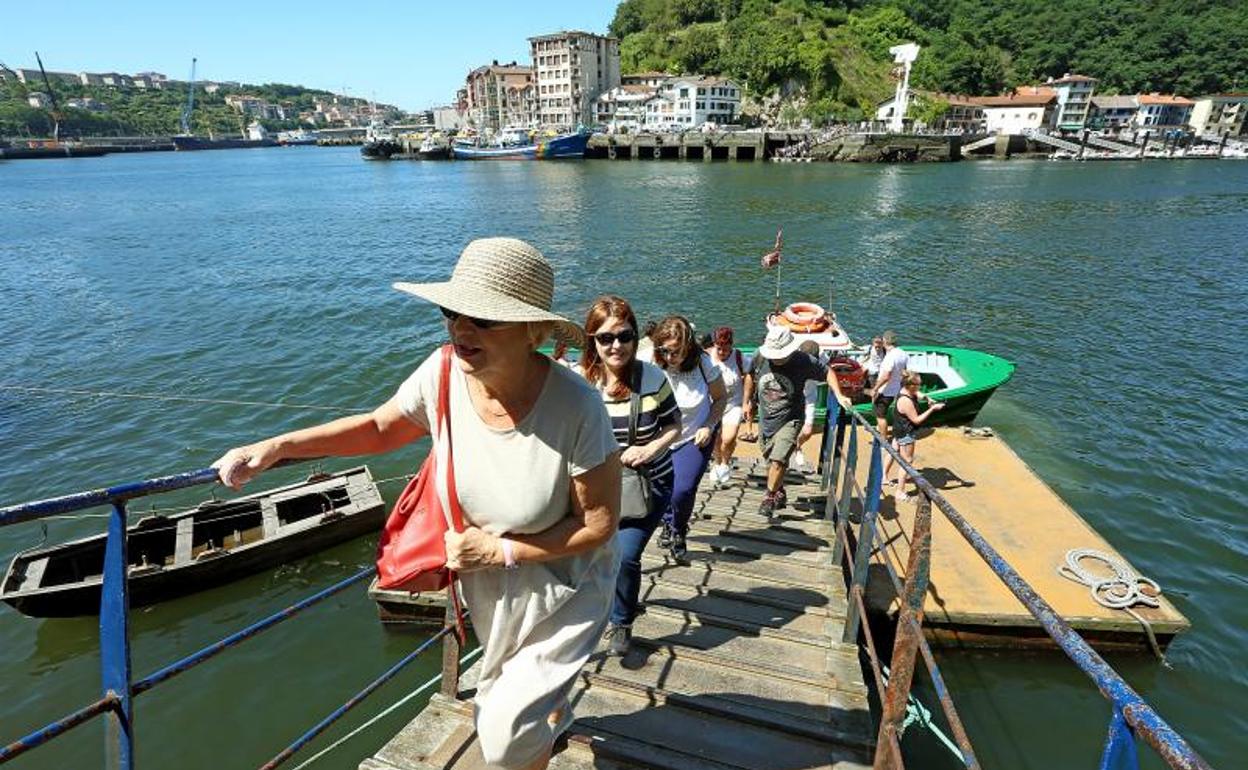 Un grupo de turistas desciende de un barco en Pasaia tras realizar un paseo. 
