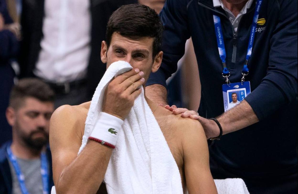 El médico trabaja sobre el lesionado hombro de Djokovic. 