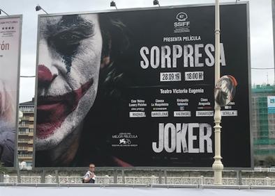 Imagen secundaria 1 - Arriba, fotograma de 'Joker', la película sorpresa que se proyectará el día de la clausura. A la izquierda, el cartel publicitario frente al María Cristina. A la derecha, una de la imágenes de la exposición de Sandro Miller en la que aparece John Malkovich caracterizado como Joker. 