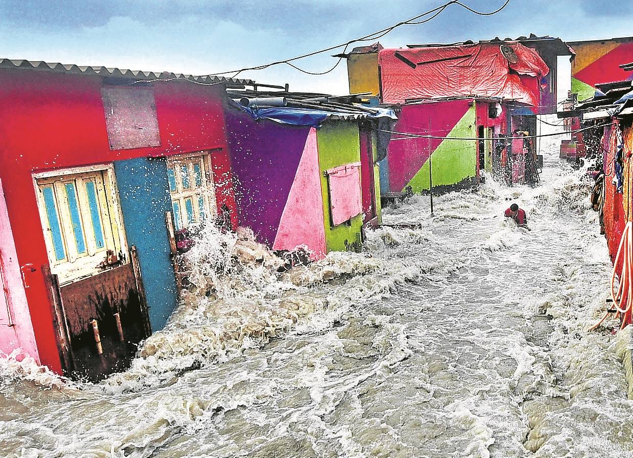 Una riada arrastra a un vecino en un barrio de Bombay.