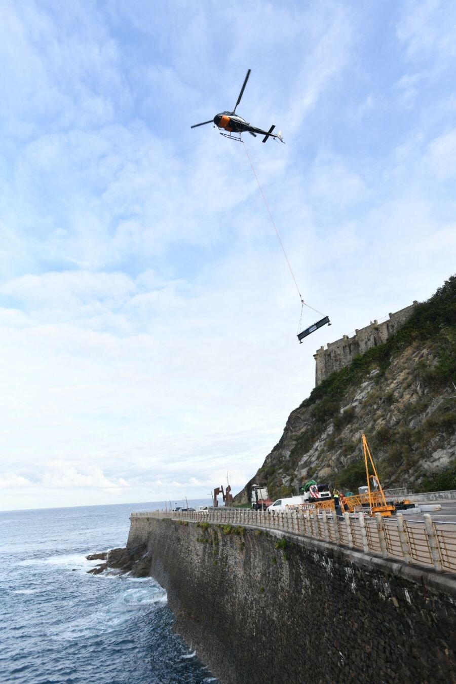 Un helicóptero ha sido el encargado de trasladar, por piezas, la grúa para la obra del Faro.