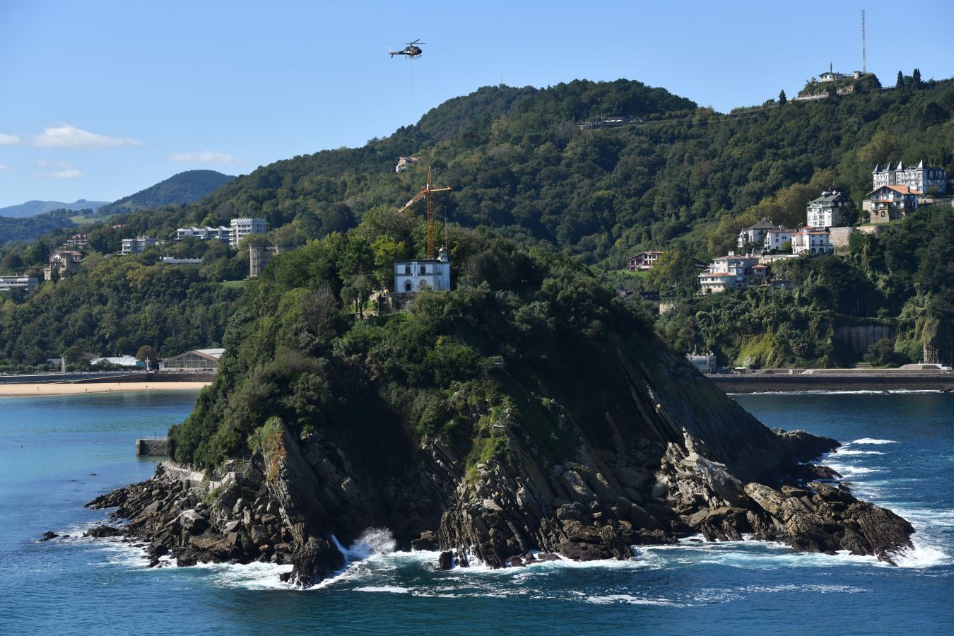 Un helicóptero ha sido el encargado de trasladar, por piezas, la grúa para la obra del Faro.