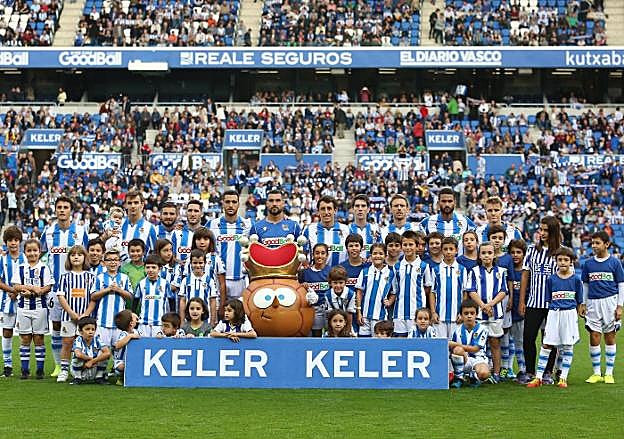 El equipo titular ayer posa con los niños y niñas antes de que empezara a rodar el balón. 