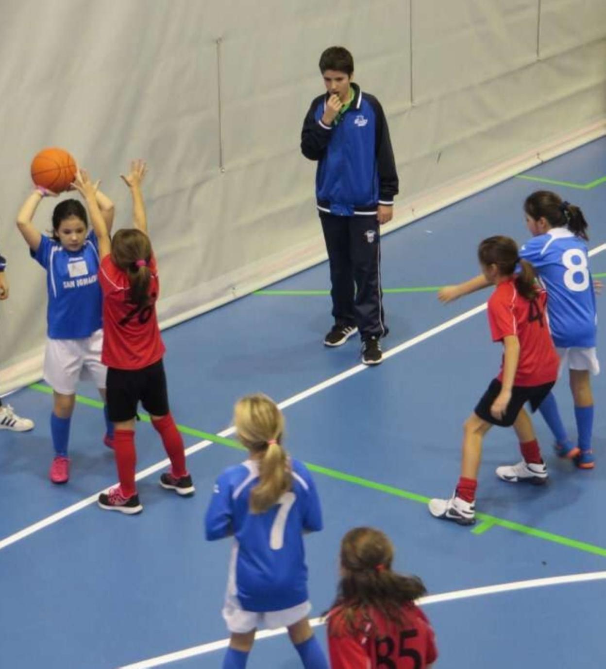 Dos equipos de niñas disputan un partido de baloncesto. 