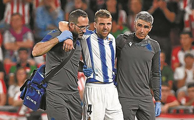 Lesionado. Illarramendi se retira del campo en San Mamés el 30 de agosto sin poder apoyar el pie sujetado por el fisioterapeuta Imanol Soroa y el doctor Javier Barrera.