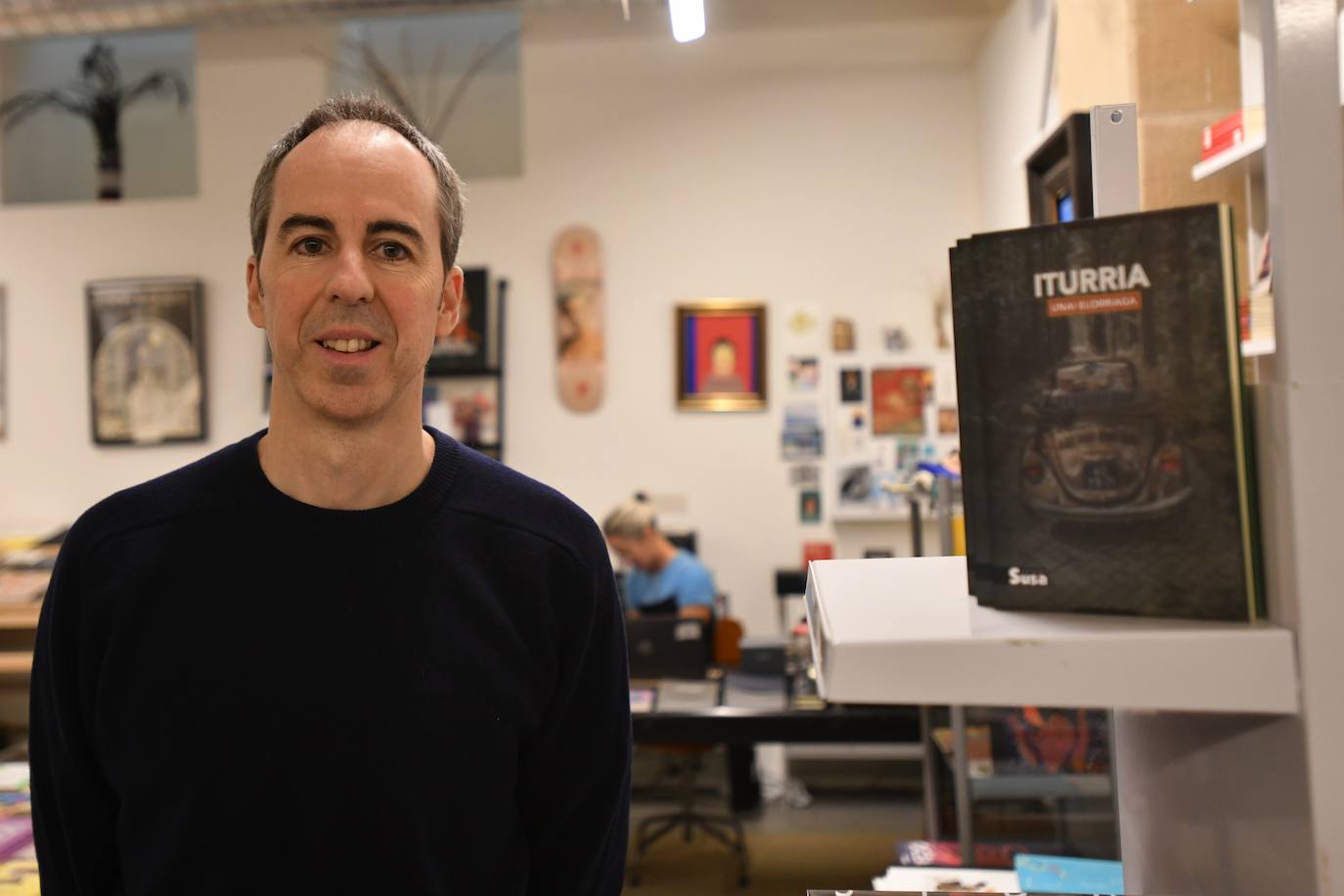 Unai Elorriaga, bere liburu berriaren zenbait ale ondoan dituela, Donostiako Tobacco Days liburu-dendan.