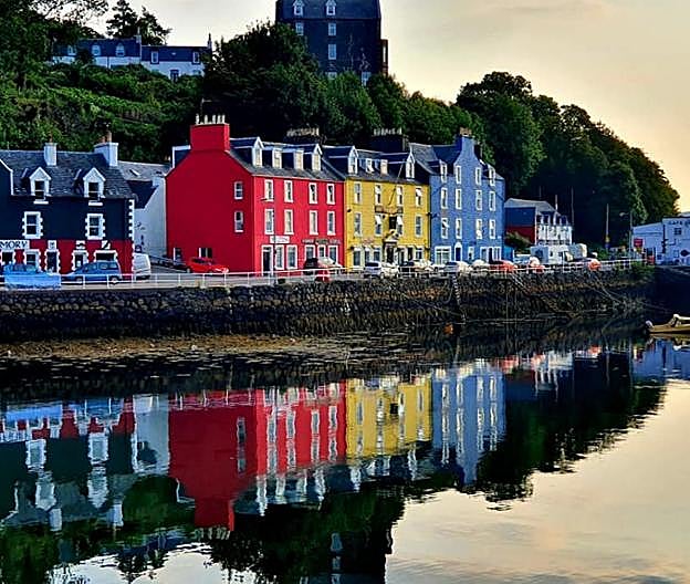 En el círculo, Colin Morrison al volante de su camión de basura. Junto a estas líneas, algunas de sus fotos: barcazas en Salen, casas de colores de Tobermory y un amanecer en la terminal del ferry de Craignure. La más grande, en la otra página, es su favorita: las vacas Highland, autóctonas de las Tierras Altas escocesas, le salen al paso en su ruta por la isla de Mull. 