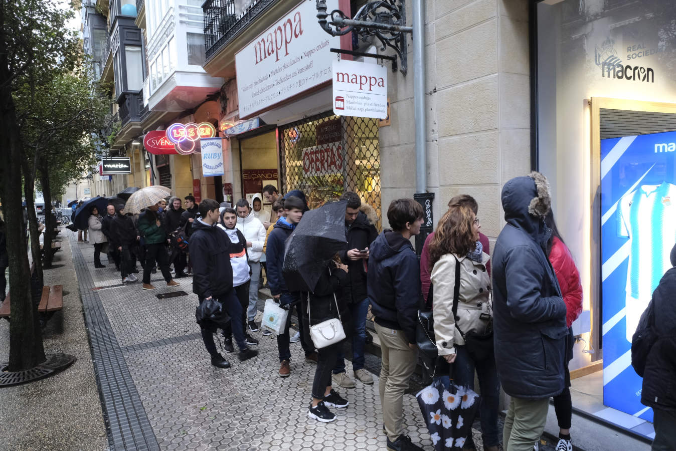 Cientos de aficionados realistas han esperado durante varias horas bajo la lluvia en las tiendas de la Real Sociedad para comprar una elástica