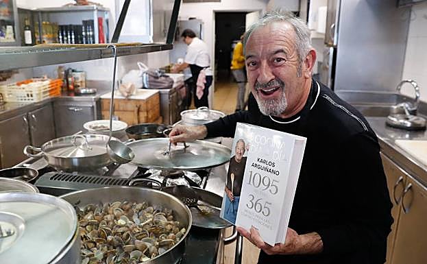 Arguiñano, con un ejemplar de su libro en la sociedad Arralde Txiki de Zarautz.