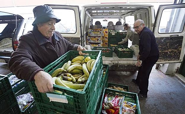 El día arranca en el almacén del Banco de Alimentos cargando los vehículos.