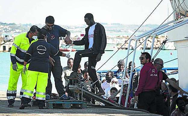 Policía y servicios médicos esperaban en el puerto italiano a los migrantes y les ayudaron a salir de la embarcación.