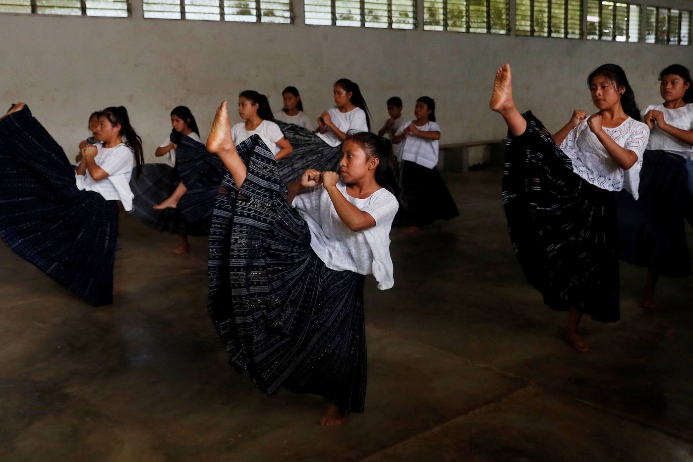 Niñas q'qchí de la aldea Tipulcan en San Pedro Carchá practican taekwondo con su maestro, Danny Coy, en una cancha de tierra en el medio de la aldea. Cada golpe es seguido por un fuerte grito que se resuena en las laderas de la zona montañosa de Alta Verapaz, en el norte de Guatemala. Con cada patada al aire, las niñas de la aldea Tipulcan espantan a los fantasmas de la violencia machista y el acoso que han sufrido en su comunidad. 