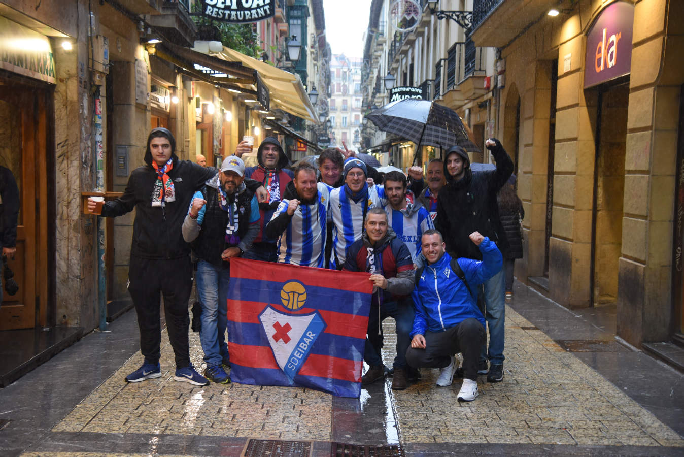 Seguidores de la Real Sociedad y Eibar han desafiado al mal tiempo y han teñido con sus colores la Parte Vieja donostiarra 