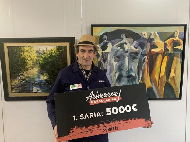 Ganador. El pintor Jokin Telleria con el cheque y la bata y el gorro del concurso.