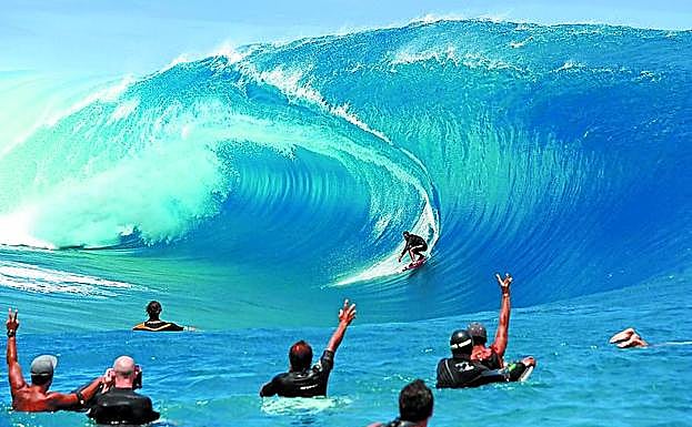 Un surfista, de espaldas a la ola, en la pared de Teahupoo. 