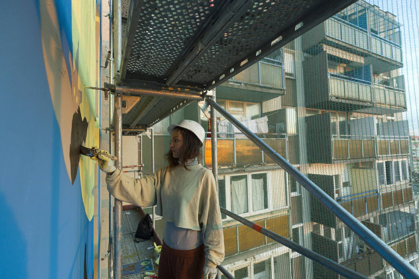 Los miembros del grupo Szines Varos (ciudad colorida) trabajan en un andamio para crear un mural en un edificio residencial en el Distrito VIII de Budapest. La obra de arte de 600 metros cuadrados representa a los personajes principales de la popular caricatura húngara Macskafogo (lit. Cat Catcher) de 1986, que se distribuyó como 'cat city' en Estados Unidos. El colectivo artístico ha realizado muchos murales a gran escala en Budapest y otras ciudades húngaras, así como en Moscú, Berlín y Londres, desde su fundación en 2008.