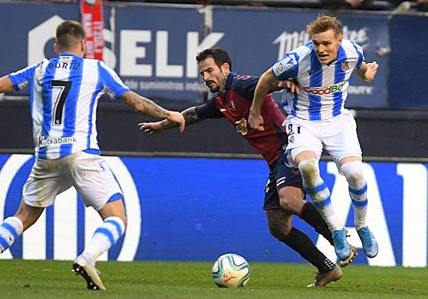 Portu y Odegaard tratan de impedir el avance de Rubén García ayer en El Sadar. 