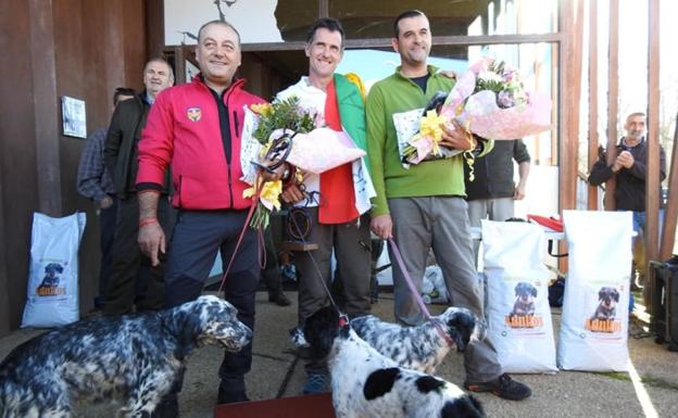 Los tres primeros clasificados del campeonato, con los premios y sus perros. 