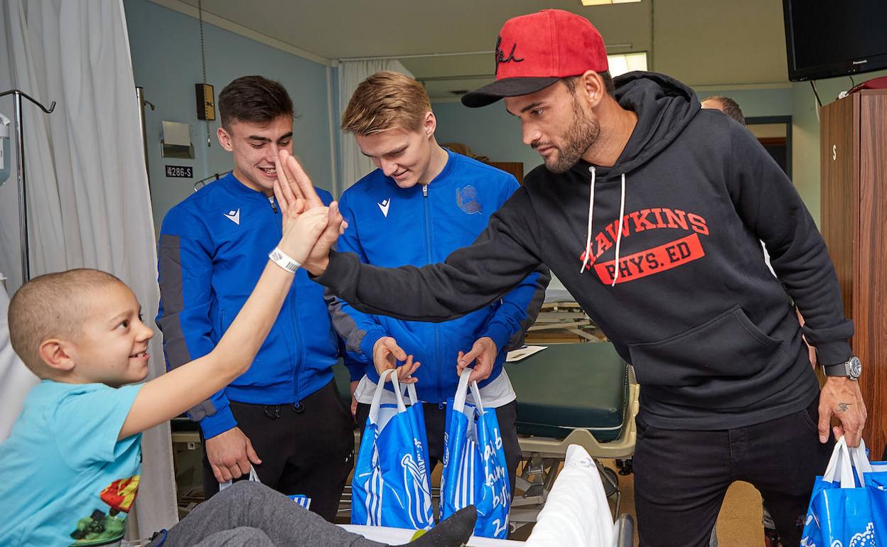 Barrenetxea, Odegaard y Willian José saludan a uno de los chavales ingresados.