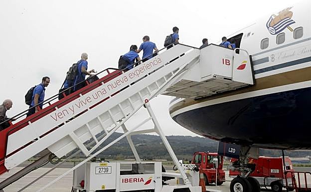 Jugadores y técnicos suben la escalerilla del avión en un desplazamiento. 