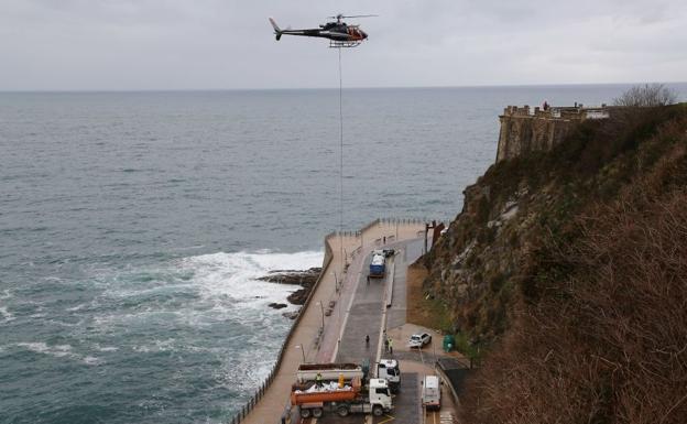 El helicóptero espera a que enganchen las bolsas. 