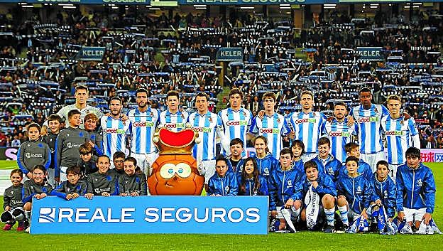 El once inicial junto con los niños y niñas que les acompañaron a la salida al campo.