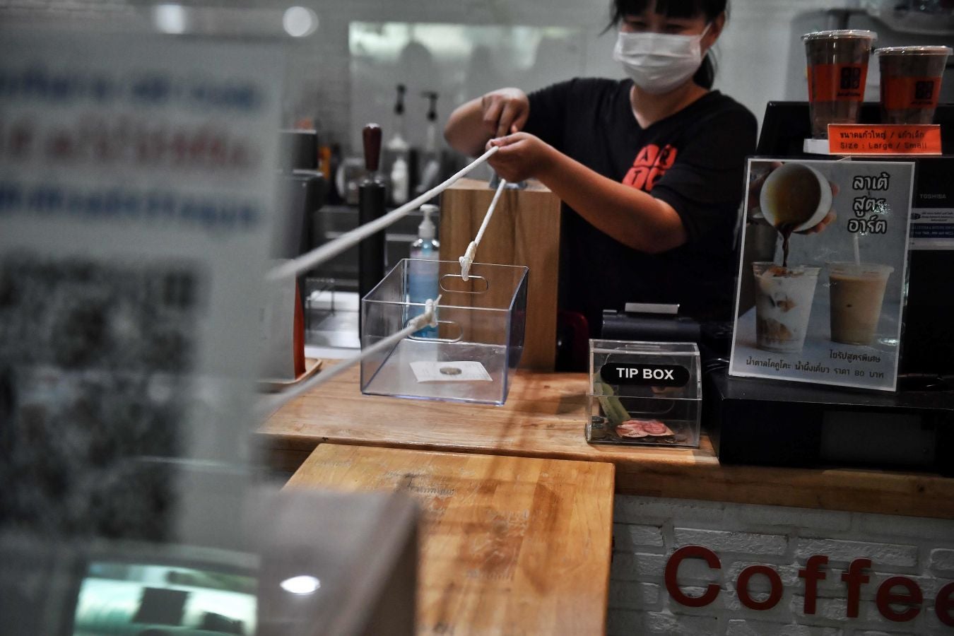 Una cafetería de Bangkok ha ideado este sistema rudimentario a la par de original para que los clientes puedan pagar sus cafés respetando las distancias de seguridad.