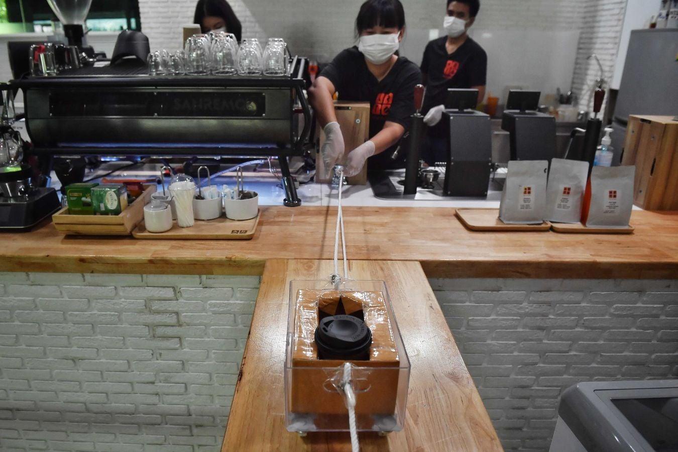 Una cafetería de Bangkok ha ideado este sistema rudimentario a la par de original para que los clientes puedan pagar sus cafés respetando las distancias de seguridad.