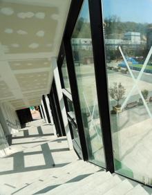 Imagen secundaria 2 - Vista exterior del edificio, una de las salas que acogerá la biblioteca y detalle de las escaleras que rodean uno de los laterales, una de las señas de identidad de la antigua panificadora.