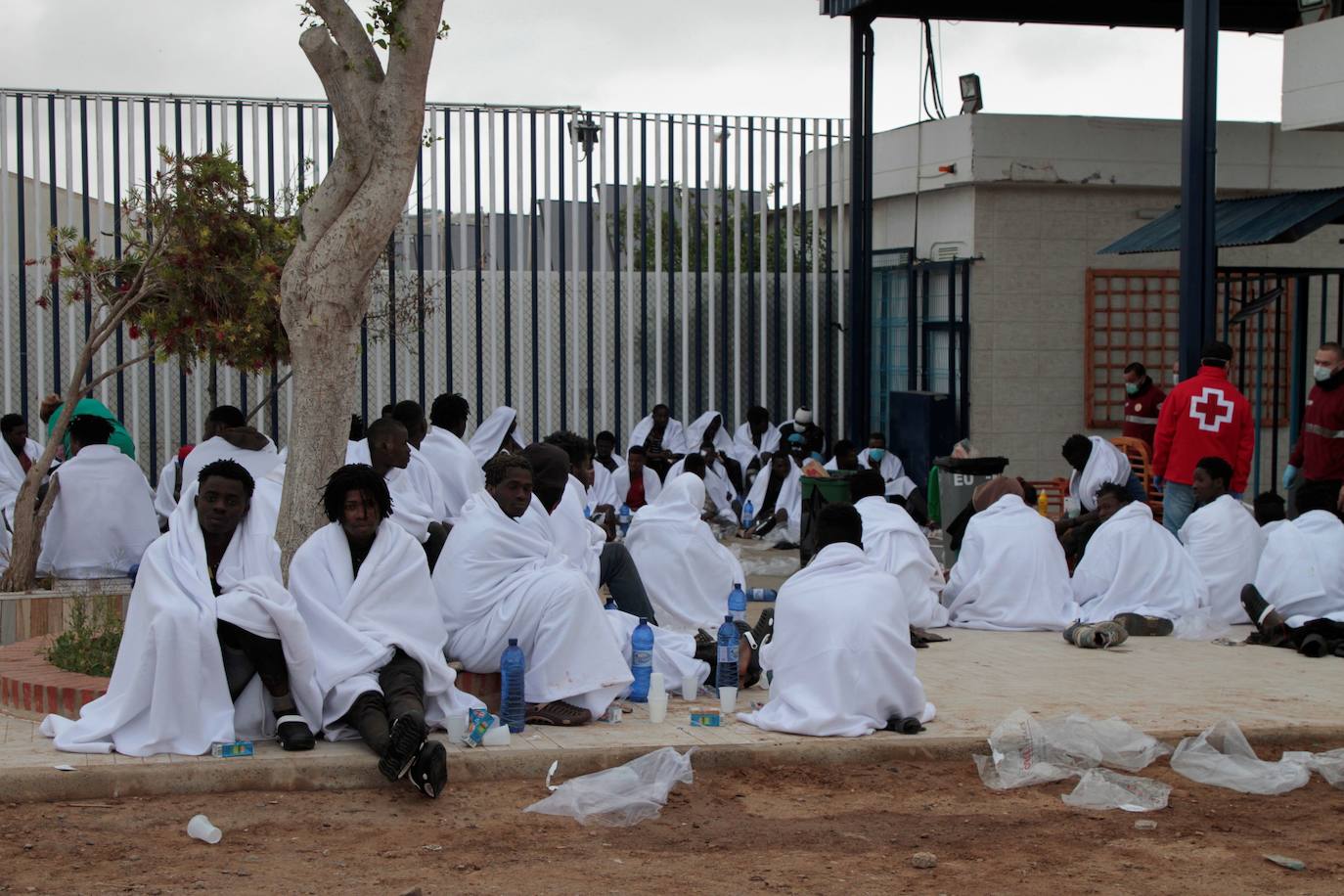Unos cincuenta inmigrantes descansan tras conseguir saltar la valla.